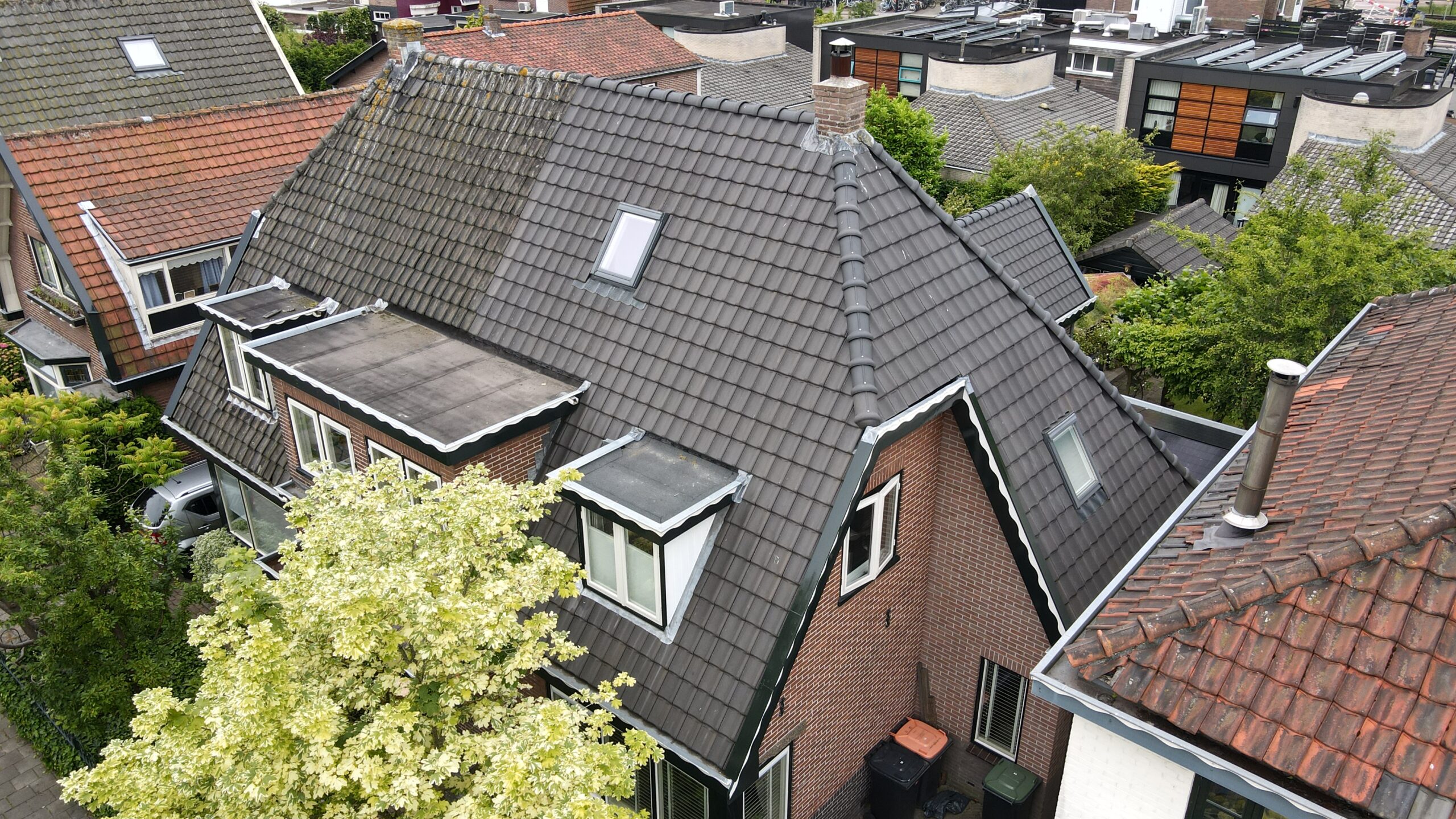 Pannendak van een woning in Castricum met dakkapellen, dakraam en schoorsteen vanuit de andere zijde